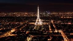 Айфеловата кула чиито блещукащи светлини очертават силуета на нощния Париж