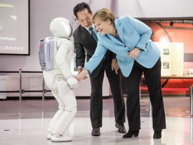 Роботът Асимо порита футбол и с Меркел