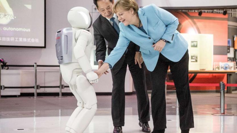 Роботът Асимо порита футбол и с Меркел